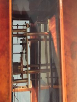Detail of glass panel on side of Brutmann clock, offering a view of the movement. Raffety Ltd