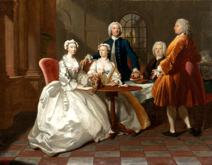 A Conversation Piece by Joseph Highmore. Typical of portraits of the period, the family is shown in an interior undertaking various pursuits. Two tripod tables (one covered with a table cloth) are being used for sewing and reading. Copyright Christie’s.